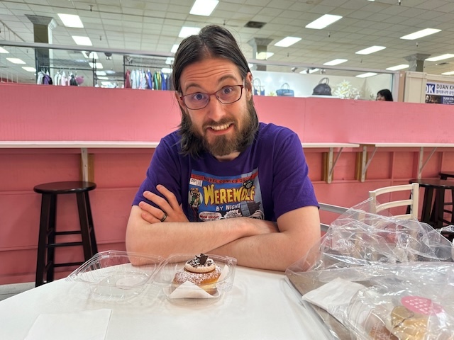 Chris holding his donut from Flour Fresh Cream Donut