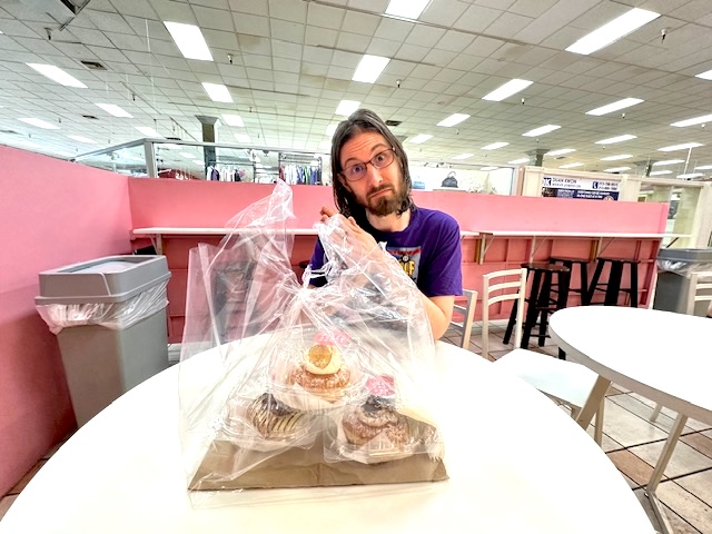 Chris holding multiple donuts from Flour Fresh Cream Donut