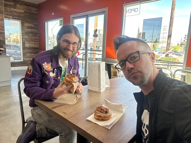 Chris and Danny inside Randy’s Donuts with donuts