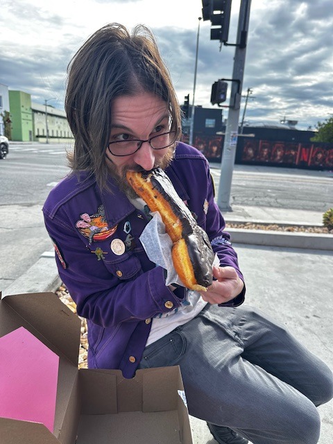 Chris with a novelty donut at Voodoo Doughnut Hollywood