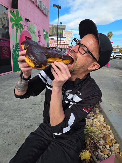 Daniel with a novelty donut at Voodoo Doughnut Hollywood